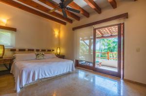 a bedroom with a bed and a large window at Escondite condominios in Zihuatanejo +90 photos