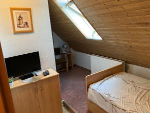 a bedroom with a bed and a desk with a television at Il tempio del Gusto in Oelsnitz