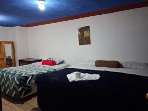 a bedroom with two beds with towels on the bed at hotel kasa kamelot parque in Quetzaltenango