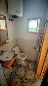 a bathroom with a sink and a toilet and a window at BlePelagos house in Glossa