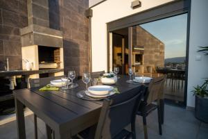 a dining room with a black table and chairs at Côa River Apartment in Vila Nova de Foz Coa