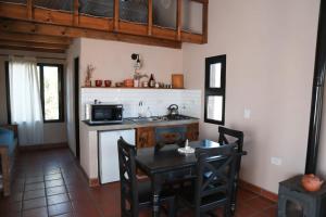 a kitchen with a table and a microwave at Alebrijescalamuchita in Villa Ciudad Parque
