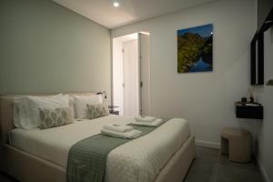 a bedroom with a bed with two towels on it at Côa River Apartment in Vila Nova de Foz Coa