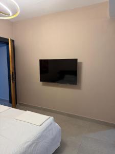 a bedroom with a flat screen tv on the wall at Hotel Zurich in Golem