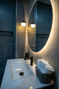 a bathroom sink with a mirror and a basket of towels at Côa River Apartment in Vila Nova de Foz Coa +60 photos
