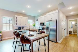 a kitchen with a table with chairs and a refrigerator at Bentonvilla in Bentonville