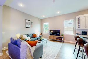 a living room with a blue couch and a tv at Bentonvilla in Bentonville