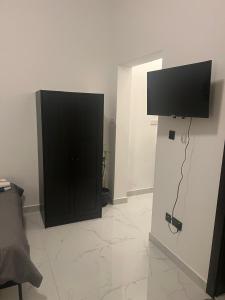 ein Zimmer mit einem schwarzen Schrank und einem Flachbildfernseher in der Unterkunft Infinity Signature in Abu Dhabi
