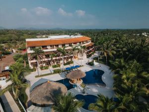 an aerial view of a resort with a pool and palm trees at Escondite condominios in Zihuatanejo