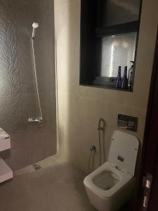 ein Badezimmer mit Toilette, Waschbecken und Spiegel in der Unterkunft Infinity Signature in Abu Dhabi