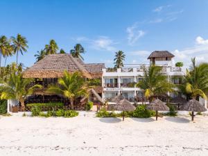 a resort on the beach with palm trees and umbrellas at Isla Bonita Zanzibar Beach Resort in Matemwe