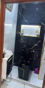 a bathroom with a toilet and a black wall at Oran Choupot boulevard principale in Oran