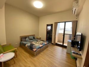 a bedroom with a bed and a tv in a room at 海豚灣 in Donggang