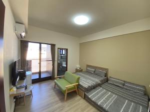 a room with two beds and a couch and a television at 海豚灣 in Donggang