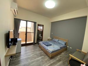 a bedroom with a bed and a television in it at 海豚灣 in Donggang