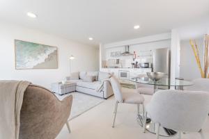 a white living room with a white couch and a glass table at Casa Rosa Panoramic Seaview in Lagoa