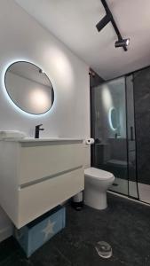 a bathroom with a sink and a toilet and a mirror at Suite Marina Gallega in Oya +11 photos