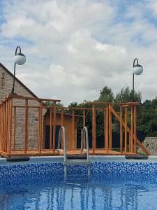a wooden deck next to a swimming pool at Chatka na Górce in Okół