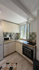 a kitchen with white cabinets and a stove top oven at Lime by Kotor in Muo