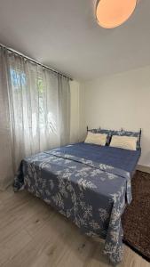 a bedroom with a bed with a blue blanket and a window at Lime by Kotor in Muo