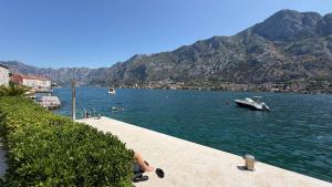 a boat in a body of water with mountains at Lime by Kotor in Muo