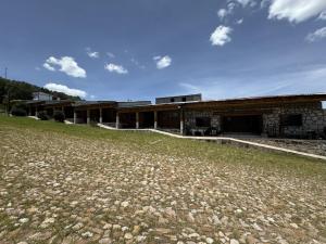 a building with a field in front of it at Hotel Nuevo Barrancas del Cobre in Creel