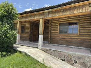 a log cabin with a porch and a window at Hotel Nuevo Barrancas del Cobre in Creel