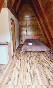 a bedroom with a bed in a wooden cabin at Chalé do Campo in Palmeira