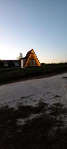a barn with a lit up roof in a field at Chalé do Campo in Palmeira