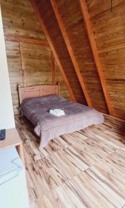 a bed in the attic of a wooden cabin at Chalé do Campo in Palmeira