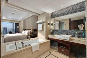 a hotel bathroom with a bed and a tub and a sink at Crowne Plaza Taizhou by IHG in Taizhou