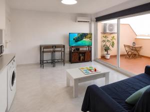 a living room with a couch and a tv at Ático Cassinello Roquetas in Roquetas de Mar