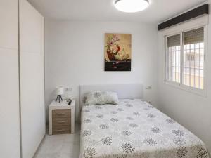 a bedroom with a bed and a picture on the wall at Ático Cassinello Roquetas in Roquetas de Mar +21 photos