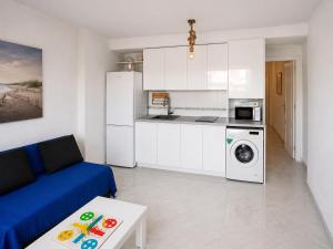 a living room with a blue couch and a kitchen at Ático Cassinello Roquetas in Roquetas de Mar