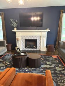 a living room with a fireplace with a tv above it at The Legacy House in Topeka
