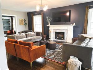 a living room with couches and a fireplace at The Legacy House in Topeka