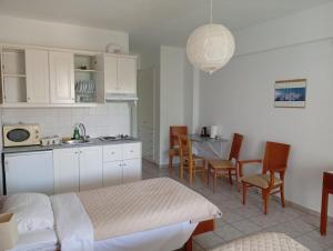 a kitchen with a bed and a table and chairs at Gikas Apartments Triple Studio Garden View A2 in Marmari
