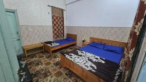 a bedroom with two beds and a door to a room at Galiyat City hotel in Mingāora