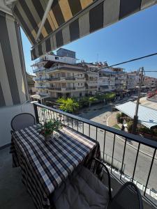 a table on a balcony with a view of a city at Luxury & Modern Apartment in Paralia Katerinis
