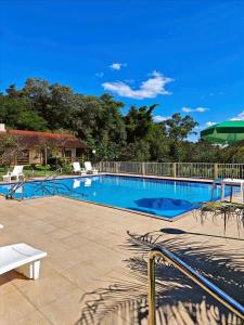 a large swimming pool with a white fence at Park Golf Hostel Ipelandia in Foz do Iguaçu