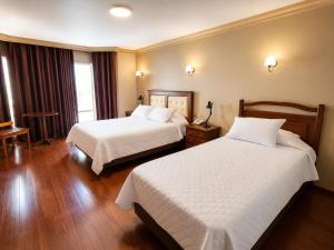 a hotel room with two beds and a window at El Prado Hotel in Cochabamba +28 photos