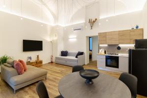 a living room with a table and a couch and a kitchen at Dimore Sangiuliano in Catania
