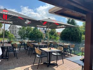an outdoor patio with tables and chairs and umbrellas at Il tempio del Gusto in Oelsnitz