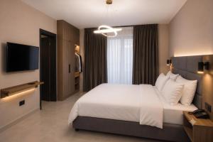a bedroom with a large bed and a television at Hotel Zurich in Golem +17 photos