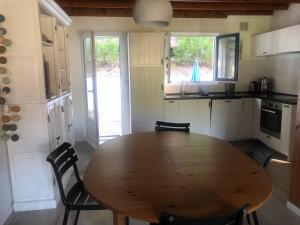 a kitchen with a wooden table and chairs at Maison calme Quend-Plage Petite Californie in Quend-Plage