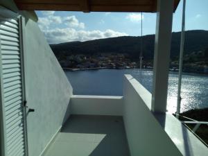 a balcony with a view of a body of water at Nicolas Rooms in Fiskardo