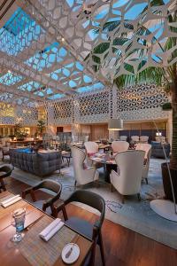 a restaurant with tables and chairs and a large ceiling at Mandarin Oriental, Barcelona in Barcelona