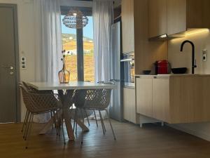 a kitchen with a table and chairs and a window at 2-bedroom villa Odysseus in Antiparos