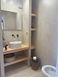 a bathroom with a sink and a mirror and a toilet at 2-bedroom villa Odysseus in Antiparos