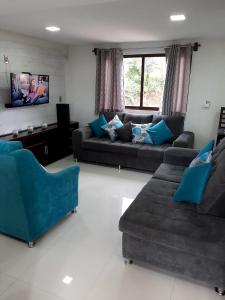 a living room with a couch and blue chairs at El descanso casa-hotel zacatlán. in Zacatlán